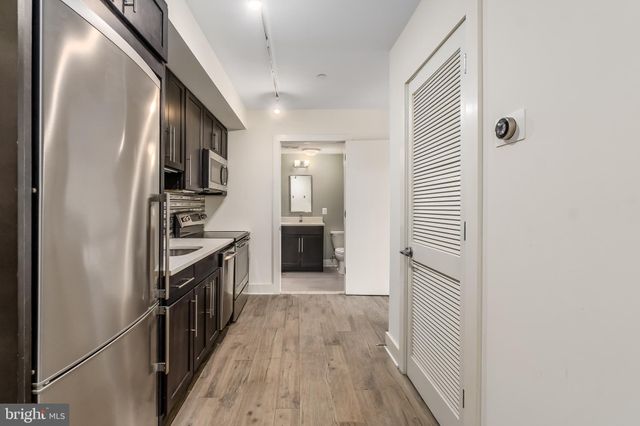 a kitchen with granite countertop cabinets stainless steel appliances and wooden floor
