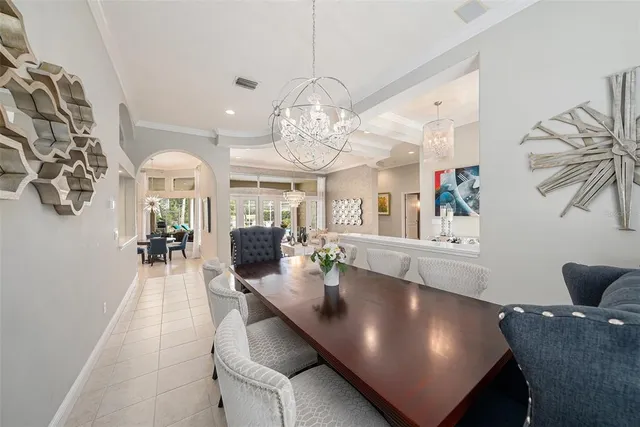 a dining room with furniture a chandelier and window