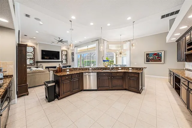 a large kitchen with a large counter top stainless steel appliances and cabinets