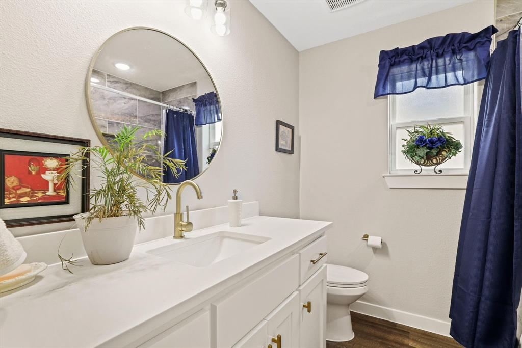 114 West Morton Street Denison, TX 75021 - Photo 17 of 21 a bathroom with a sink a toilet and a mirror