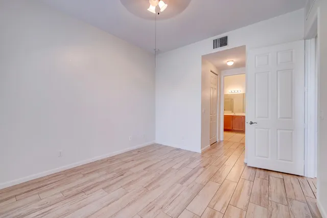 a spacious bathroom with a granite countertop sink a toilet and a mirror