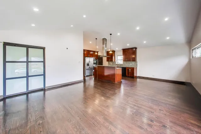 a kitchen with stainless steel appliances granite countertop a sink a stove and a wooden floors