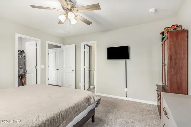 a bedroom with a bed and a flat tv screen on dresser