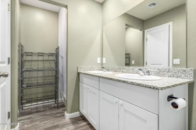 a bathroom with a granite countertop sink a mirror and shower