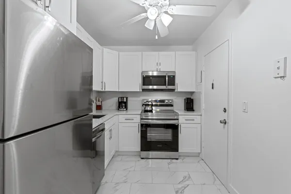 a kitchen with stainless steel appliances granite countertop a refrigerator a stove top oven a sink and dishwasher