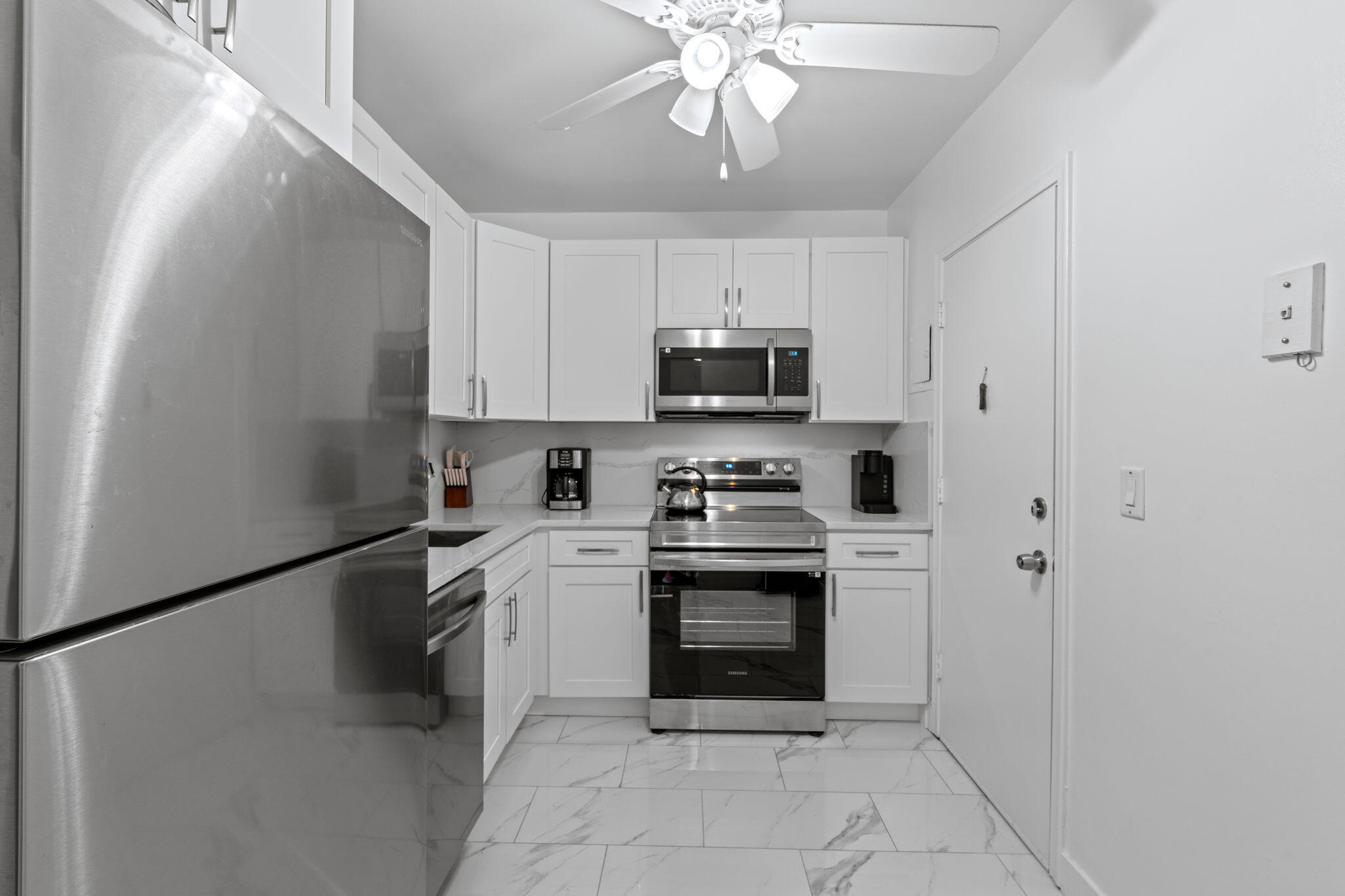 a kitchen with stainless steel appliances granite countertop a refrigerator a stove top oven a sink and dishwasher