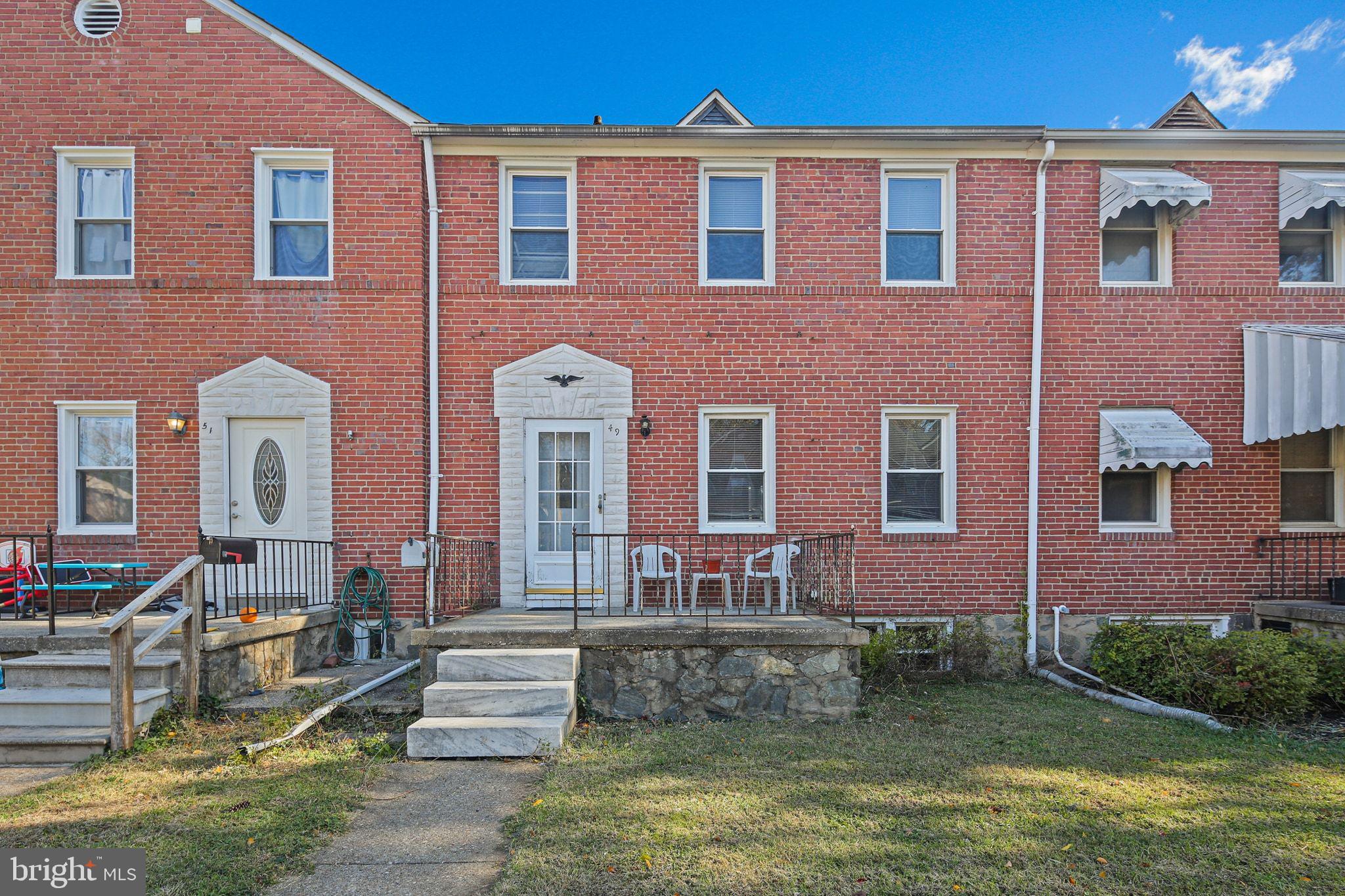 a front view of a house with a yard fire pit and outdoor seating