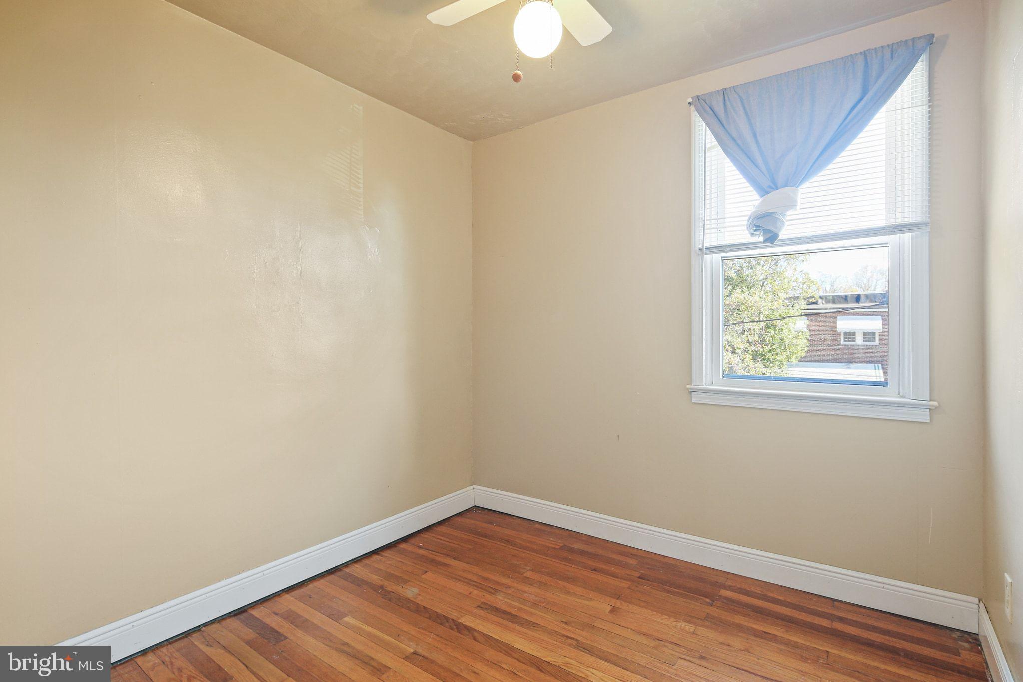 49 Briarwood Road Baltimore, MD 21228 - Photo 10 of 17 an empty room with wooden floor and windows