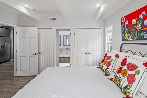 a bedroom with a bed and a painting on the wall