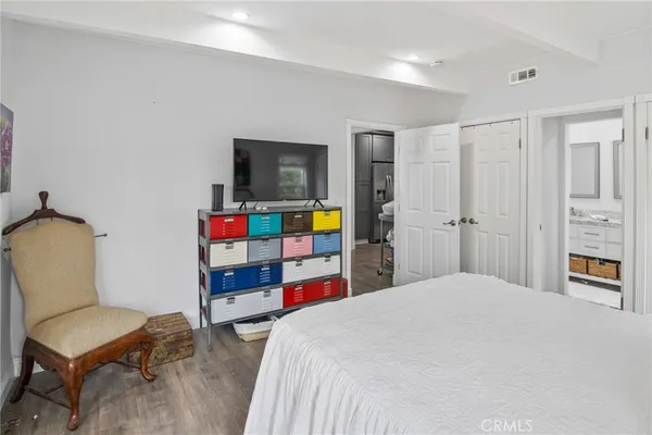 a bedroom with a bed a computer on desk and a couch