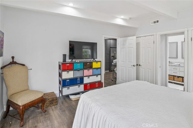 a bedroom with a bed a computer on desk and a couch