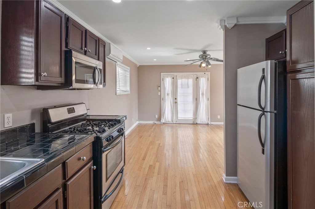 1007 Rose Avenue Pasadena, CA 91107 - Photo 38 of 52 a kitchen with stainless steel appliances granite countertop a refrigerator a stove and a sink with wooden floor