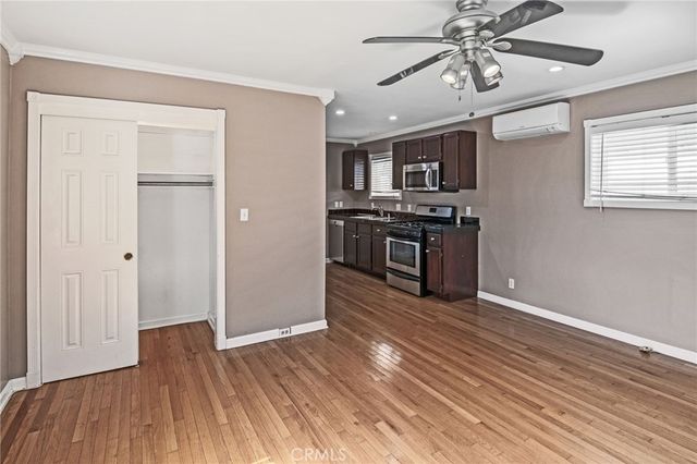 a view of a kitchen with a sink a ceiling fan and wooden floor