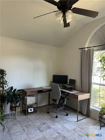 a view of a workspace with furniture and a window