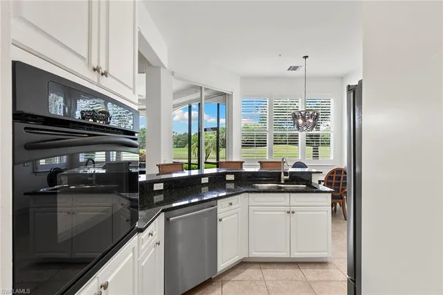 a kitchen with stainless steel appliances granite countertop a sink a stove and a microwave