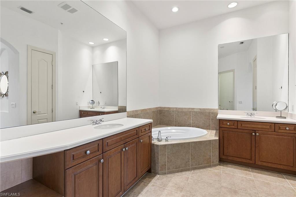 17005 Porta Vecchio Way, Unit 102 Naples, FL 34110 - Photo 18 of 50 a bathroom with a sink double vanity and a bathtub