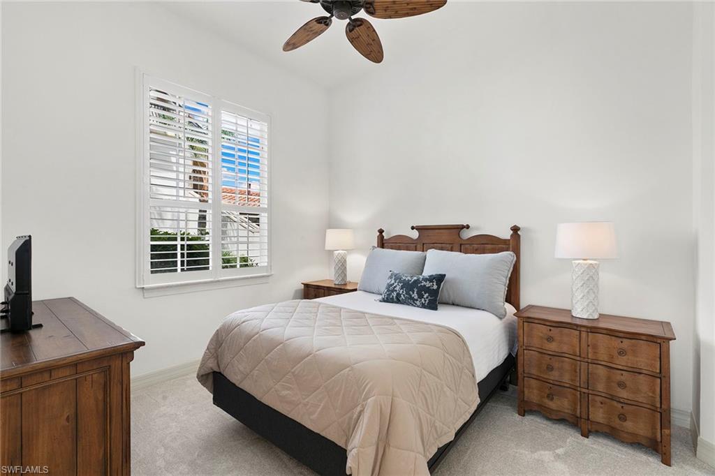 17005 Porta Vecchio Way, Unit 102 Naples, FL 34110 - Photo 21 of 50 a bedroom with a bed and a desk