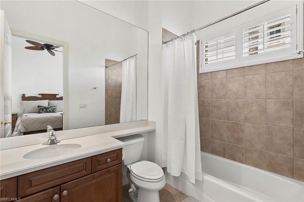 17005 Porta Vecchio Way, Unit 102 Naples, FL 34110 - Photo 22 of 50 a bathroom with a sink a toilet and a mirror
