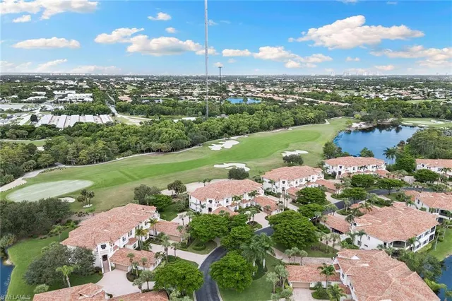 an aerial view of a city with lots of residential buildings ocean and mountain view in back