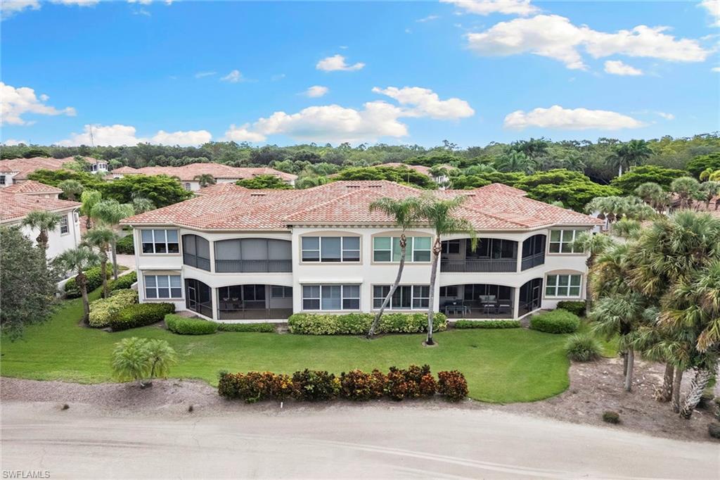 17005 Porta Vecchio Way, Unit 102 Naples, FL 34110 - Photo 37 of 50 a view of a big house with a big yard and plants