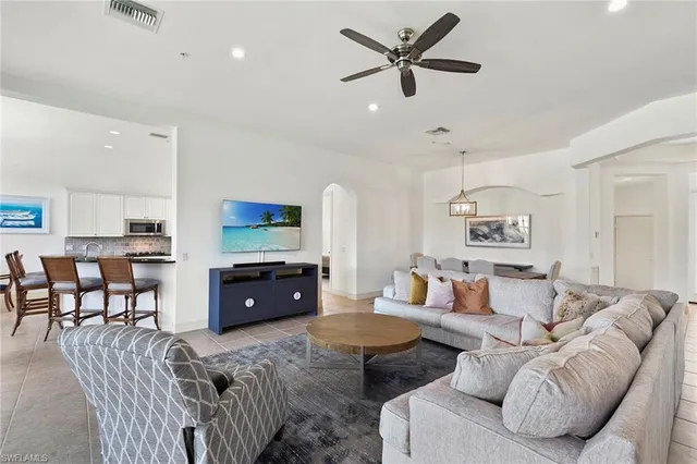 a living room with furniture a window and a flat screen tv