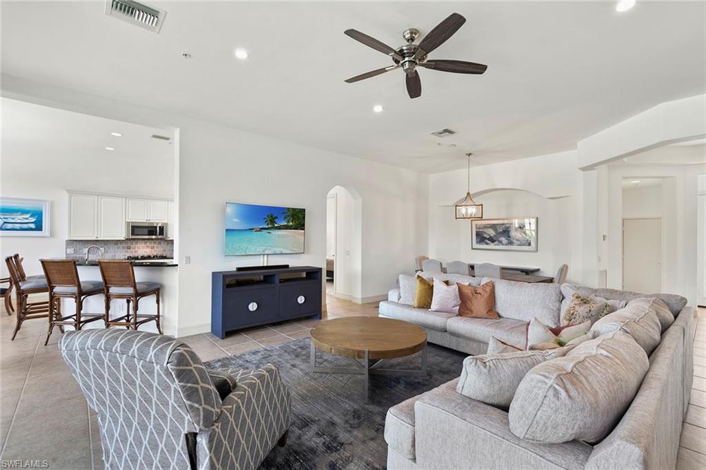 17005 Porta Vecchio Way, Unit 102 Naples, FL 34110 - Photo 4 of 50 a living room with furniture a window and a flat screen tv