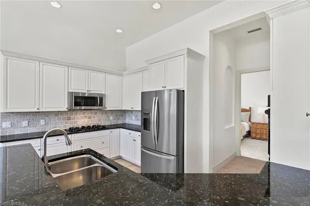 a kitchen with granite countertop a refrigerator and a sink
