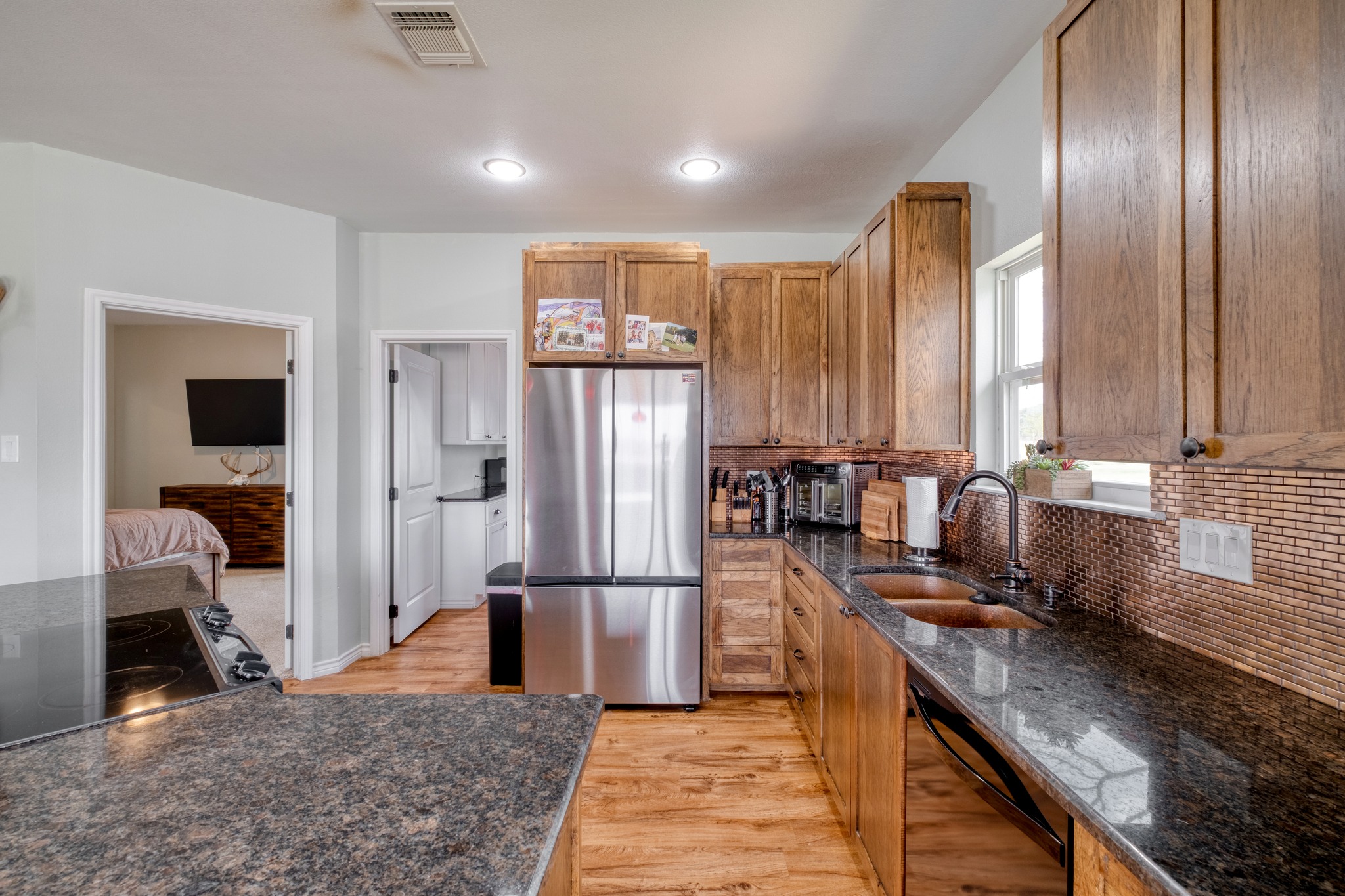 2950 County Road 484 Elgin, TX 78621 - Photo 11 of 25 a kitchen with stainless steel appliances granite countertop a refrigerator a stove and a sink with cabinets