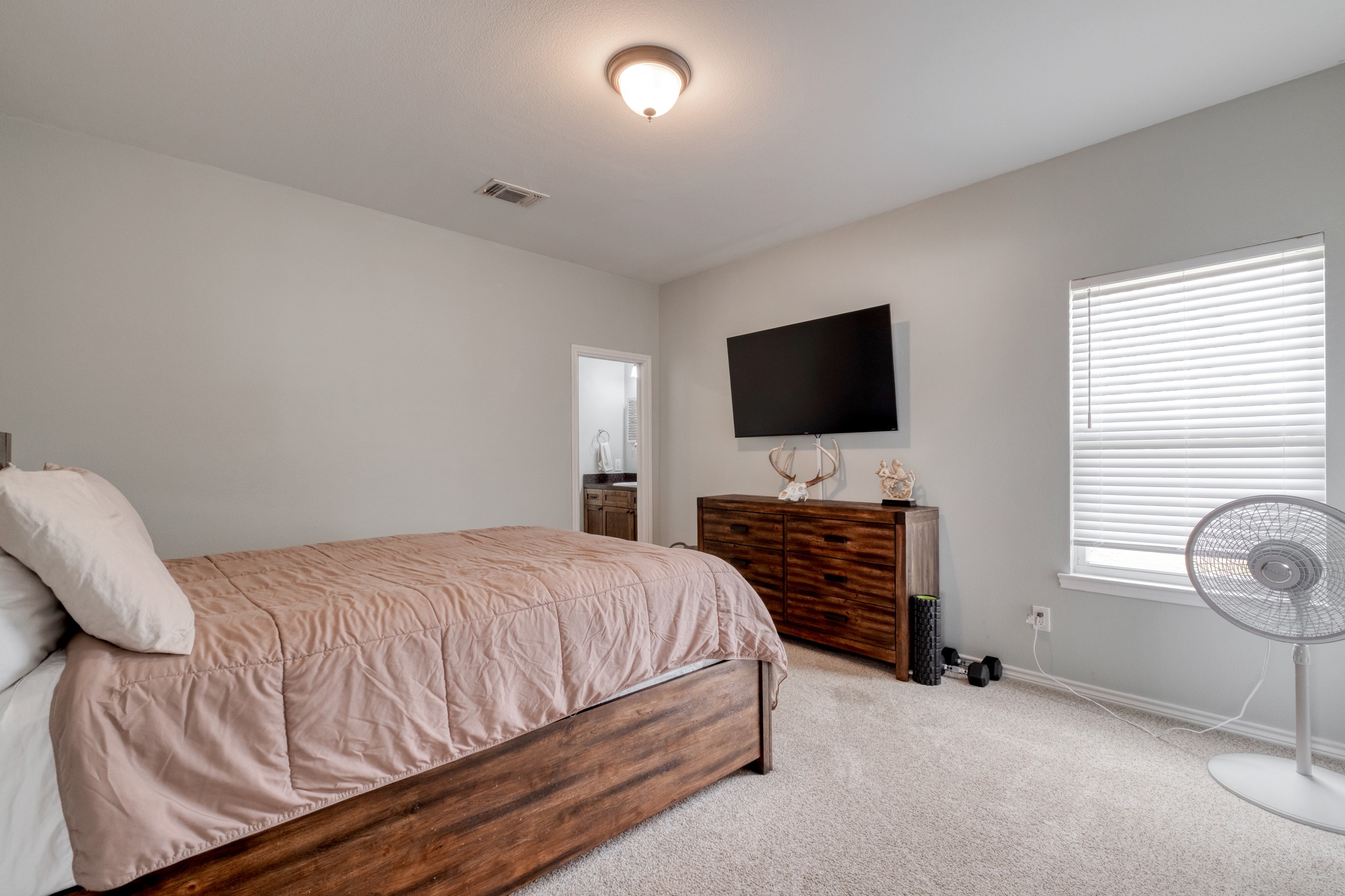 2950 County Road 484 Elgin, TX 78621 - Photo 13 of 25 a bedroom with a bed and a flat screen tv
