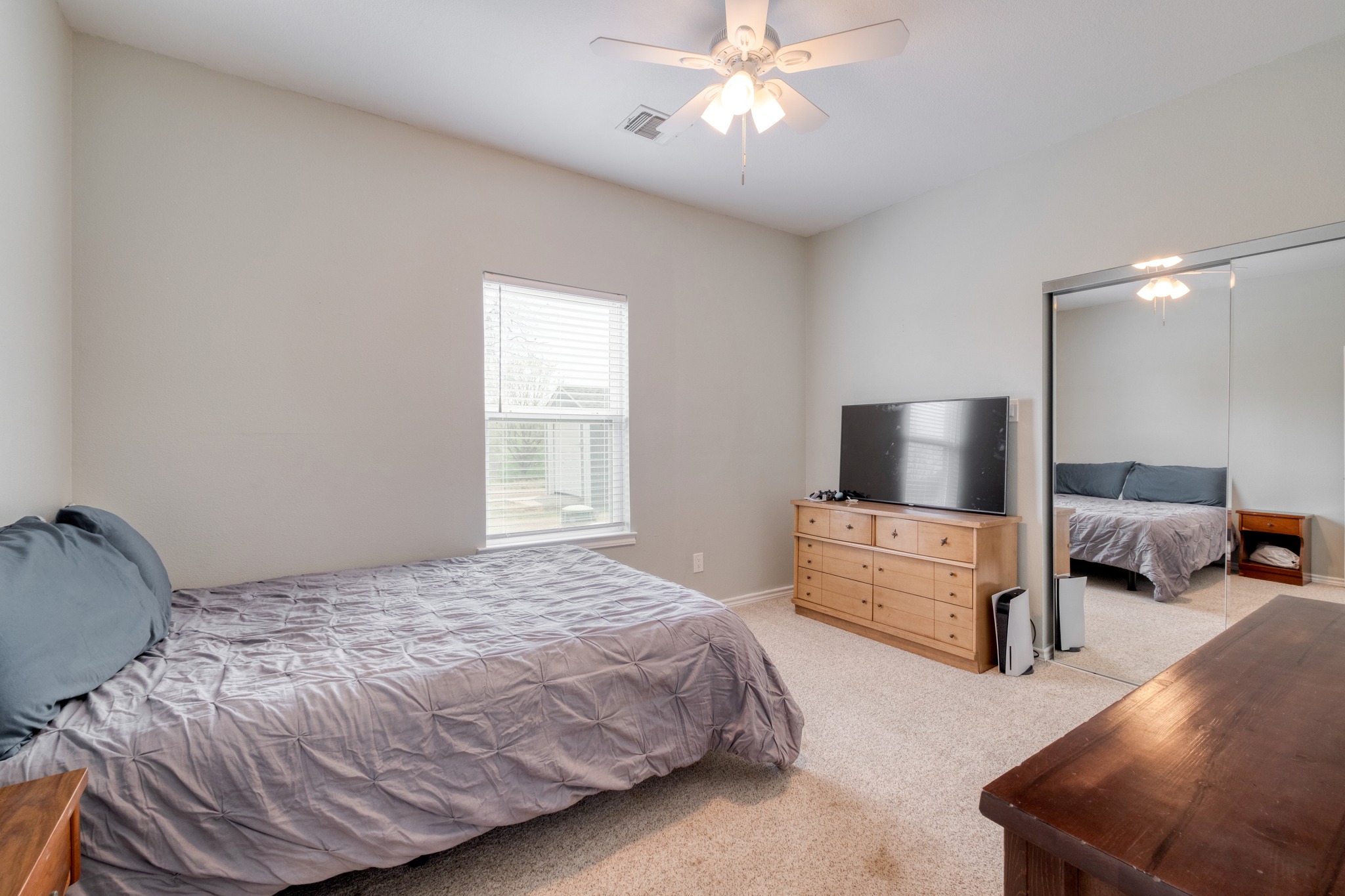 2950 County Road 484 Elgin, TX 78621 - Photo 17 of 25 a bedroom with a bed and a flat tv screen on dresser