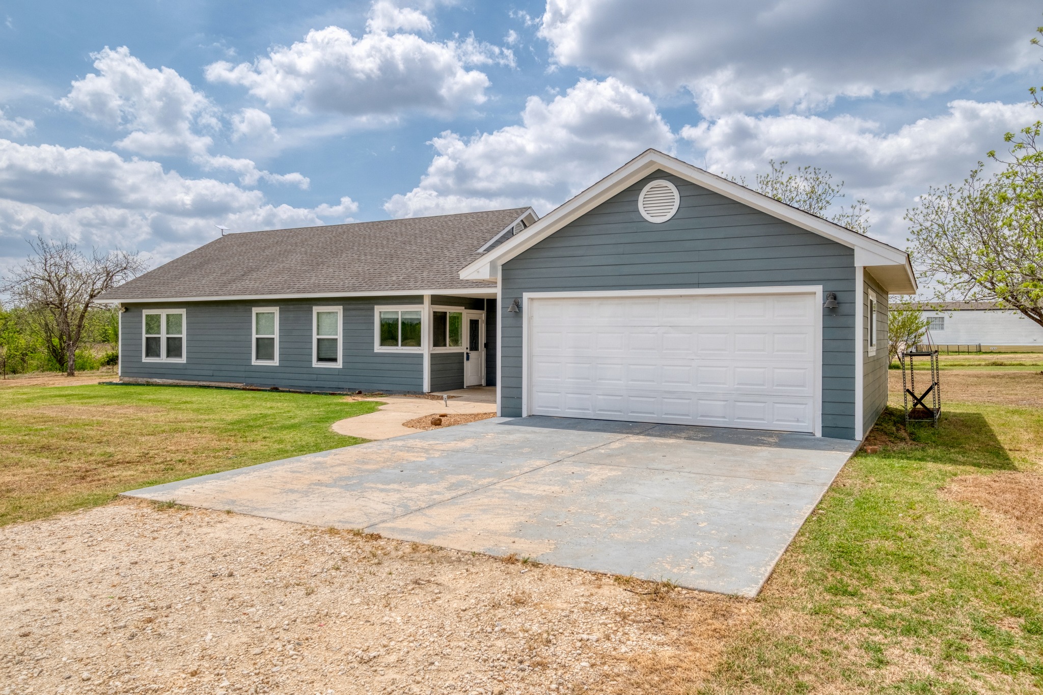 2950 County Road 484 Elgin, TX 78621 - Photo 2 of 25 a front view of a house with a yard and garage