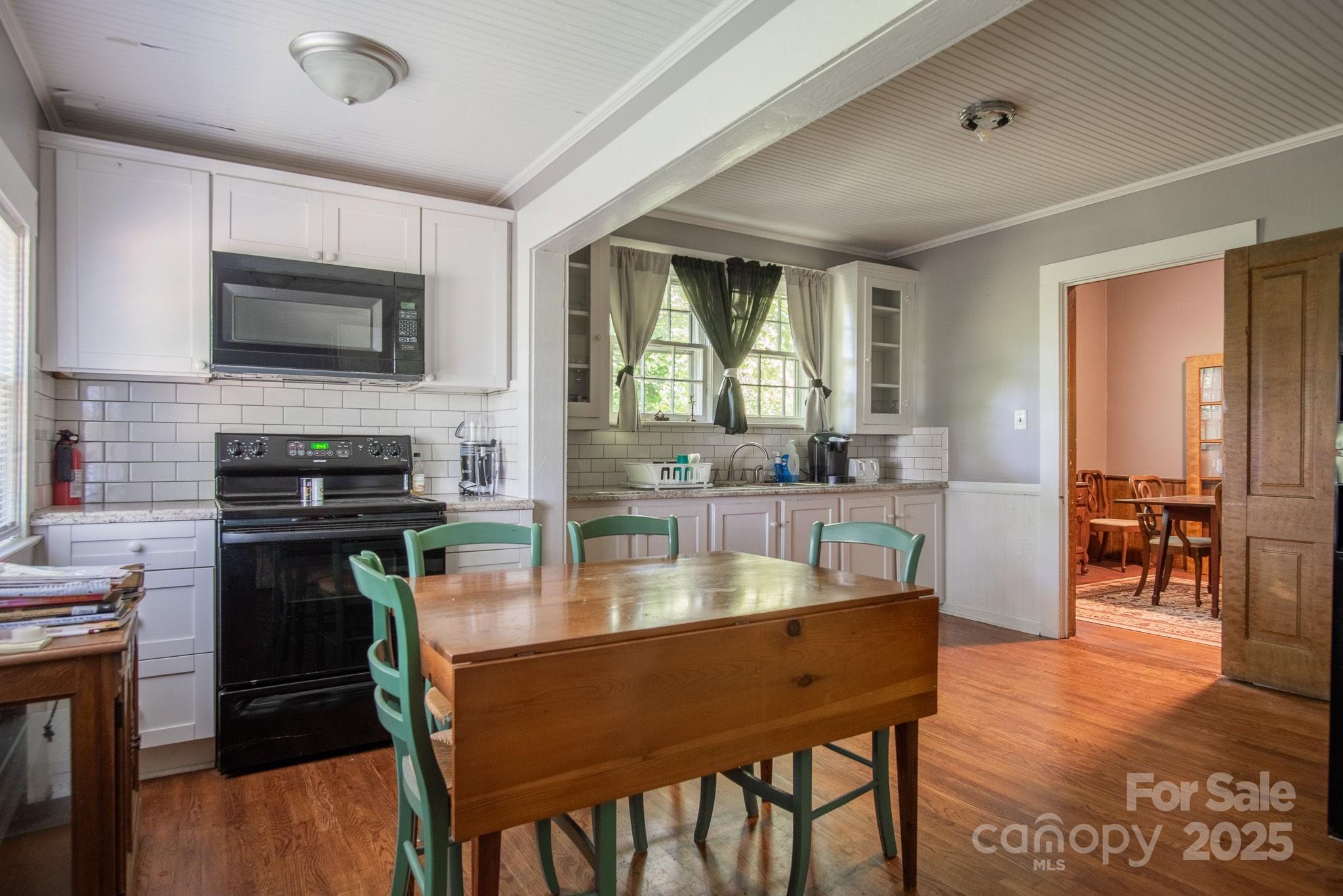 109 Fulton Street, Unit 9 Kings Mountain, NC 28086 - Photo 15 of 46 a kitchen with a table chairs microwave and cabinets