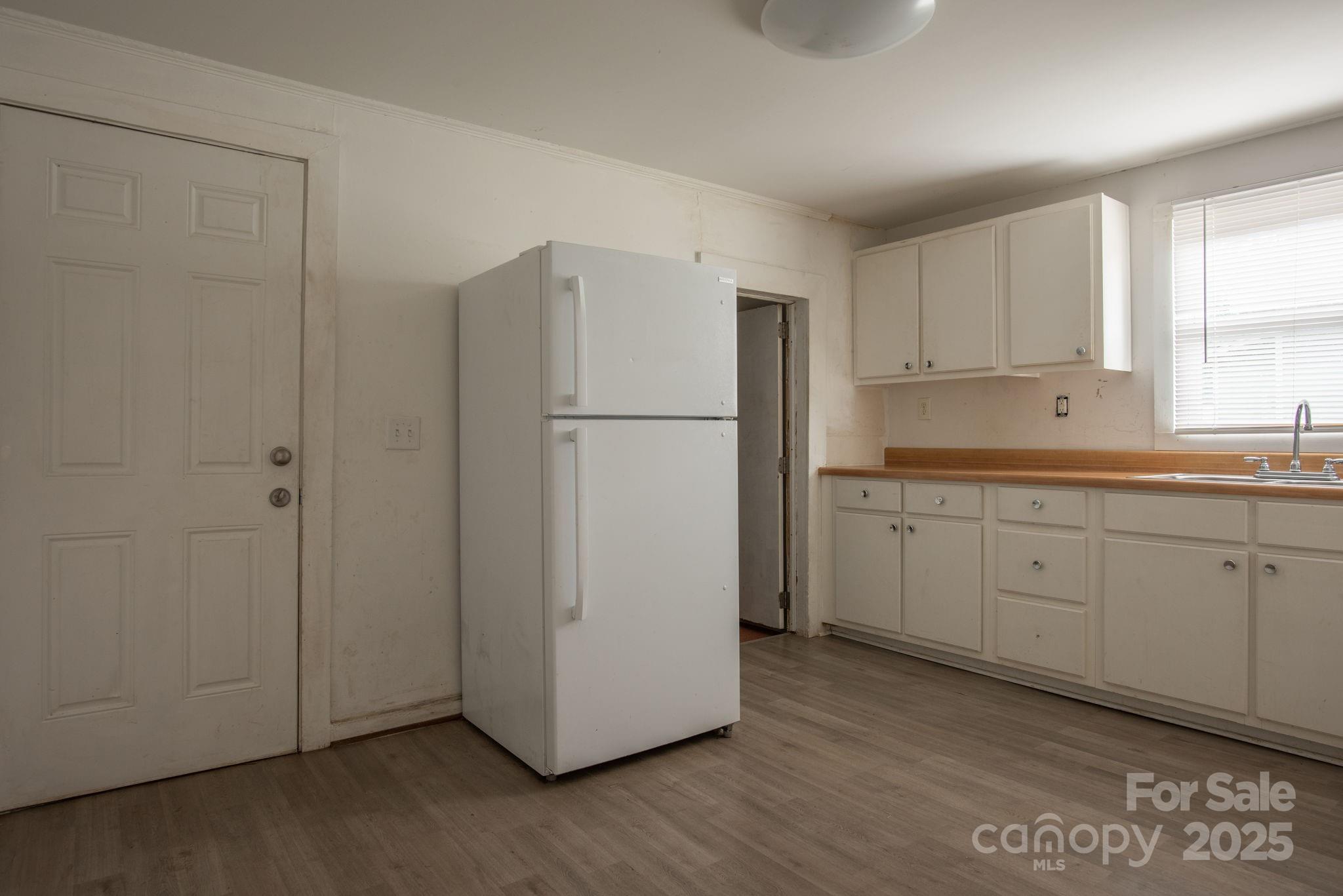 109 Fulton Street, Unit 9 Kings Mountain, NC 28086 - Photo 38 of 46 a kitchen with cabinets appliances wooden floor and windows