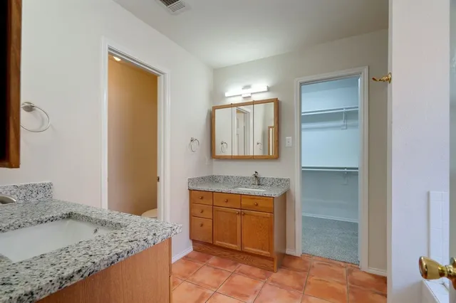 a bathroom with a granite countertop sink mirror bathtub and shower