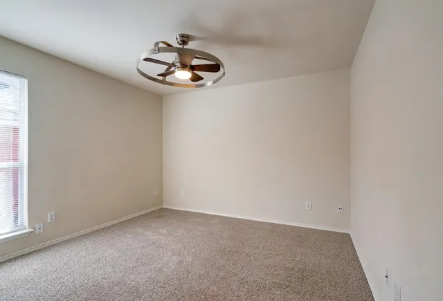 a view of empty room and chandelier fan