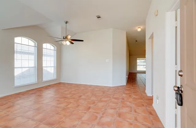 a view of a big room with windows and chandelier fan