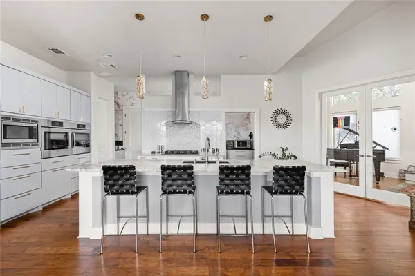 a kitchen with stainless steel appliances cabinets a stove a dining table and chairs