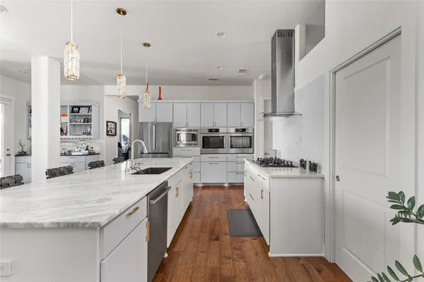 a kitchen with stainless steel appliances granite countertop a lot of counter space and wooden floors