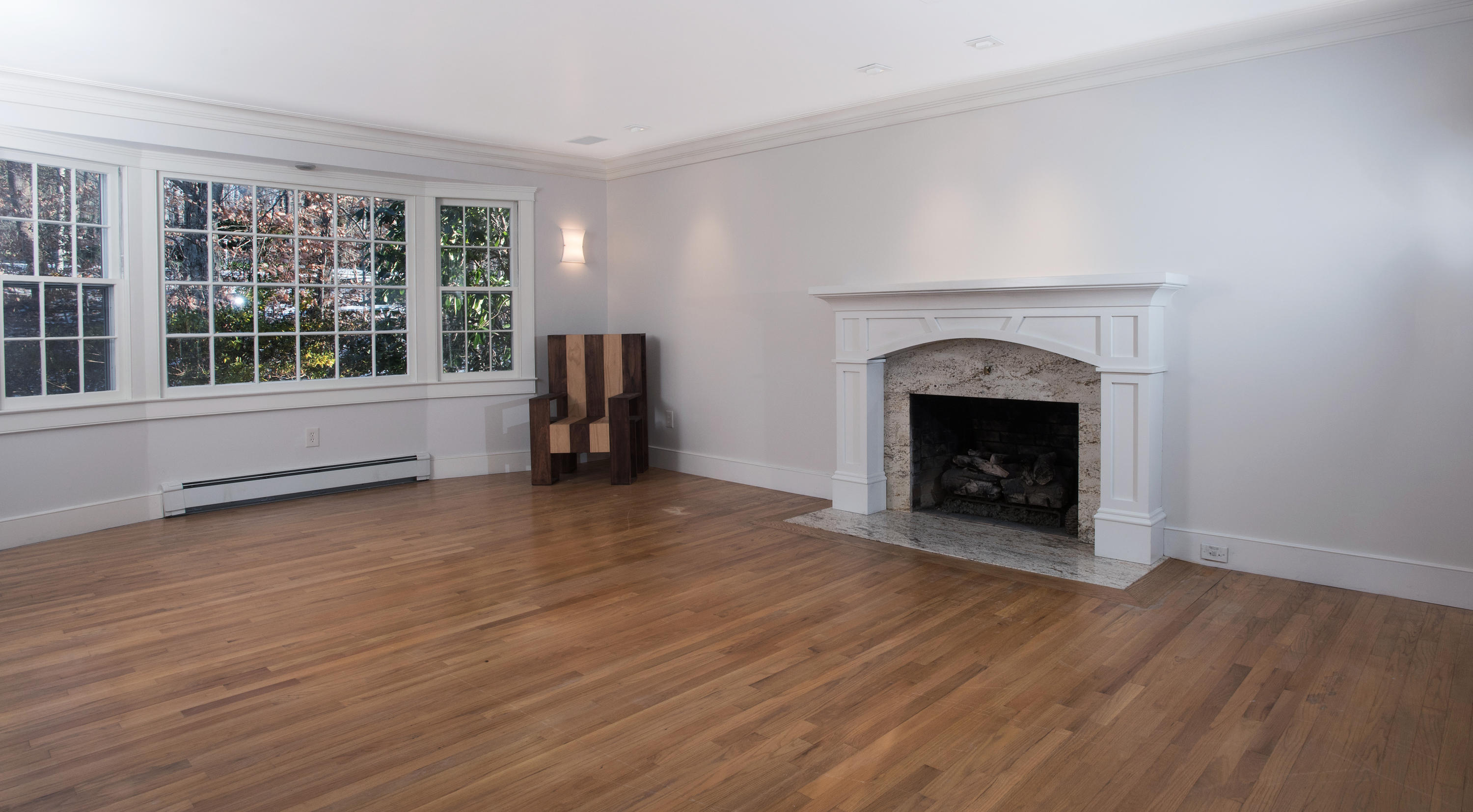 286 Indian Rock Road New Canaan, CT 06840 - Photo 5 of 24 an empty room with wooden floor and a fireplace