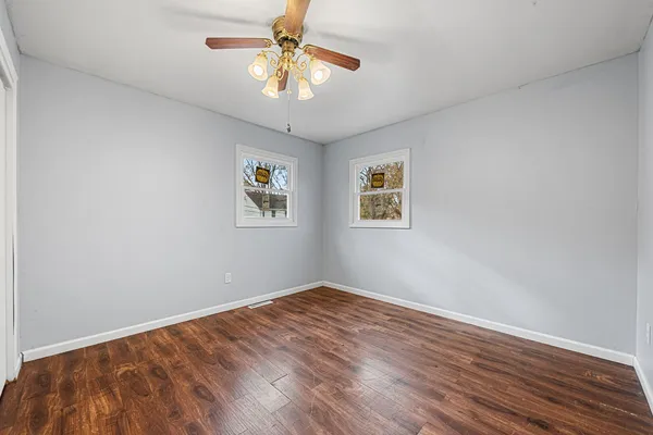 a view of empty room with wooden floor