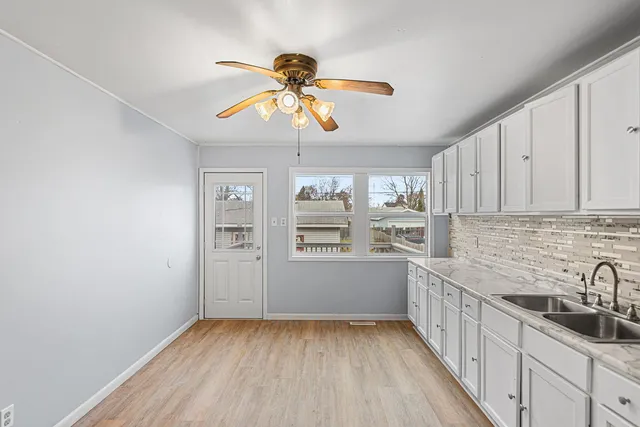 a kitchen with stainless steel appliances a white cabinets and wooden floor