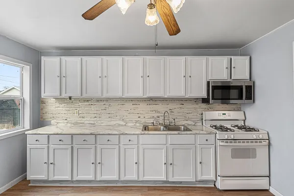 a kitchen with white cabinets and white appliances
