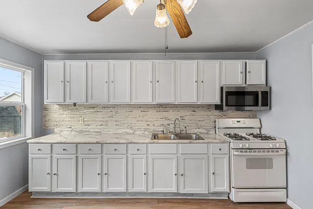 a kitchen with white cabinets and white appliances