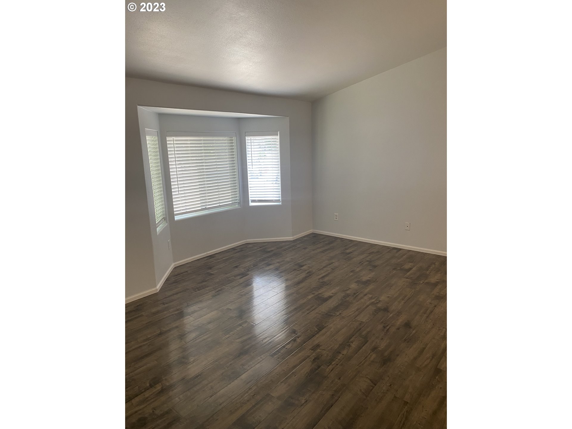 954 Aldridge Place Springfield, OR 97478 - Photo 3 of 32 a view of an empty room with wooden floor and a window