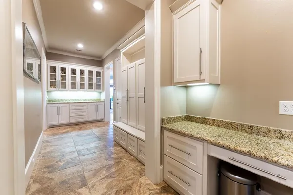 a view of kitchen with granite countertop cabinets and refrigerator