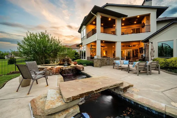 a view of a patio with couches table and chairs with wooden fence