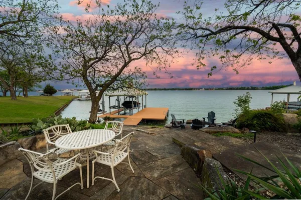 a view of two chairs and table in the patio