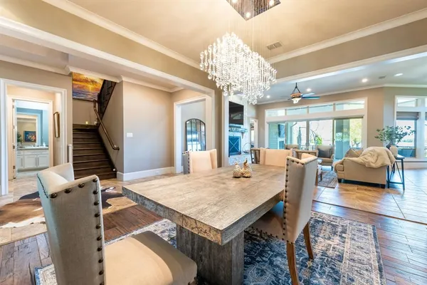 a living room with dining table and a chandelier