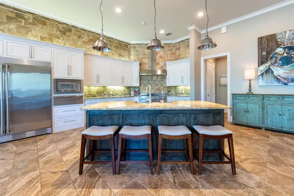 a dining room with granite countertop a table chairs and a kitchen view
