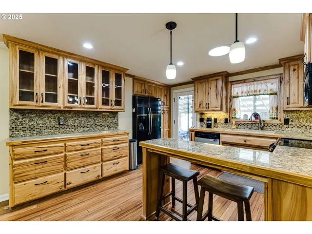 a kitchen with granite countertop white cabinets and chandelier